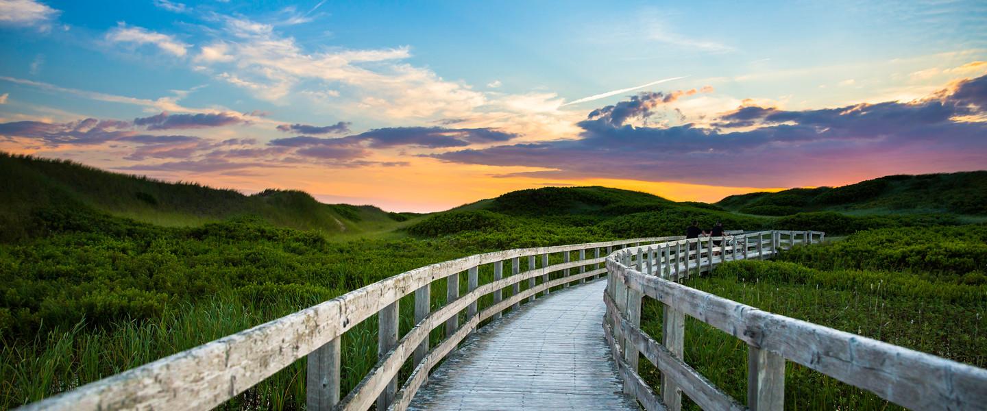 A boardwalk leading to the beach at sunset