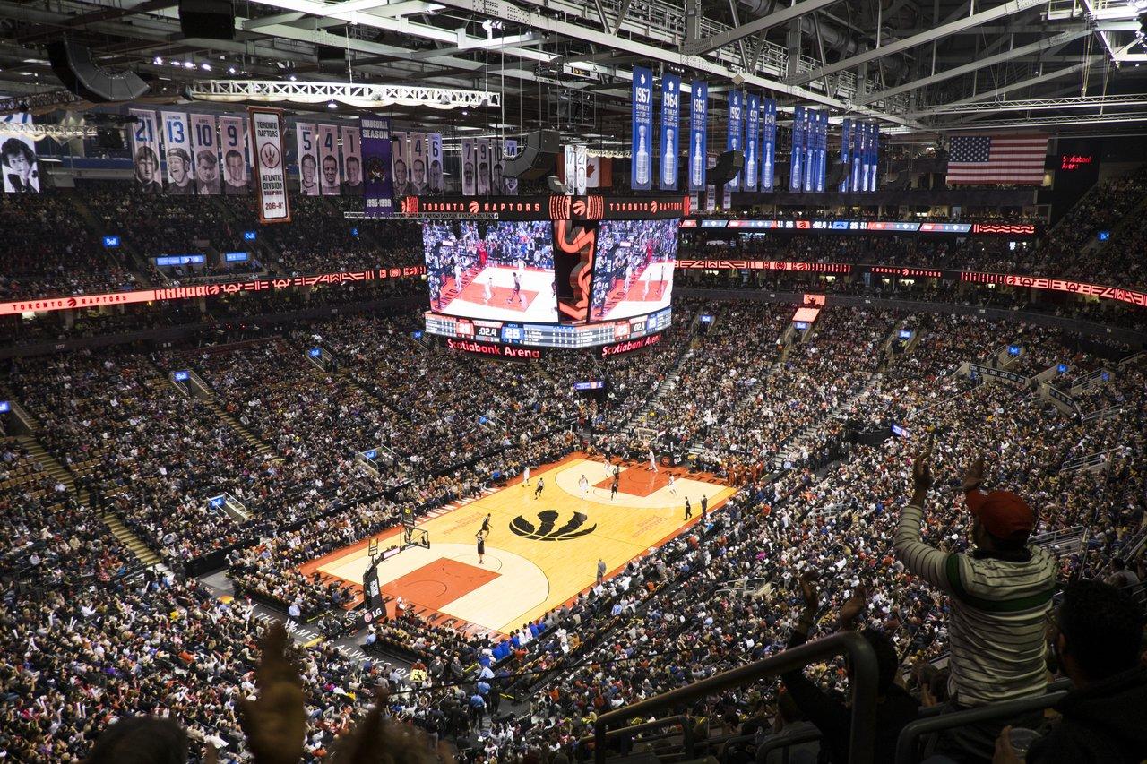 a large crowd watching the toronto raptors play basketball