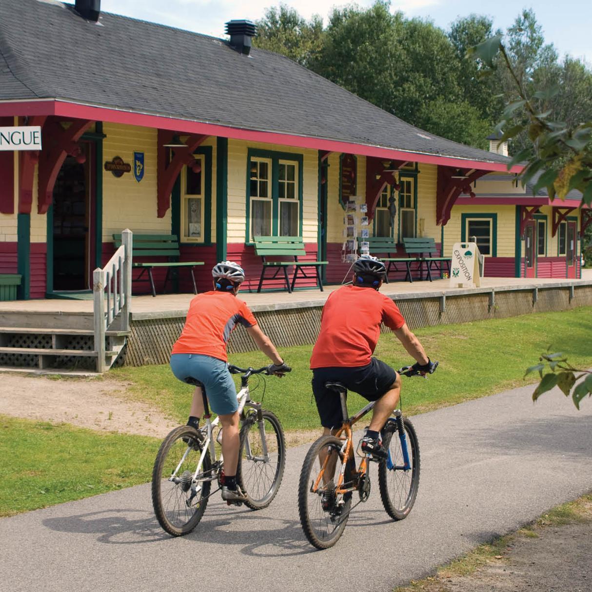 Cycling by the old train station in Nominingue, P'tit Train du Nord linear park